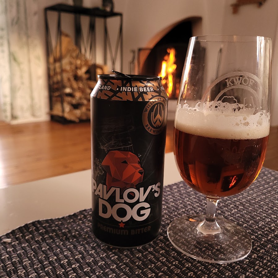 Pavlov’s Dog Premium Bitter i glas framför brasa – svensk bitter öl