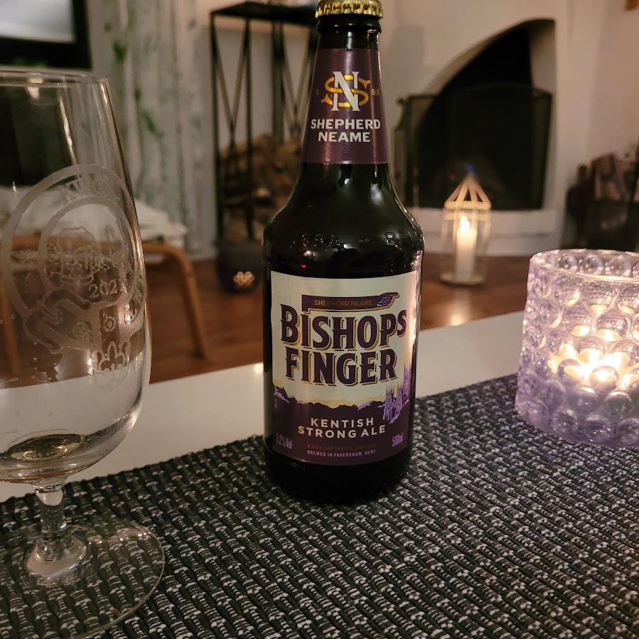 Bishop’s Finger Kentish Strong Ale i glas framför ljus – engelsk ale
